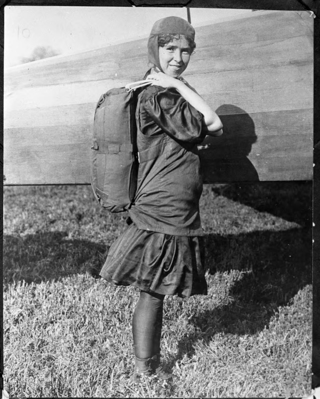 Tiny Broadwick wearing her parachute ready for a jump. Tiny was born in Granville County, North Carolina and she was the first woman to make a parachute jump from an airplane.